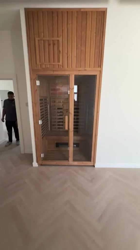 Hybrid sauna built into a spare room of a Dubai villa, timber clad with glass doors